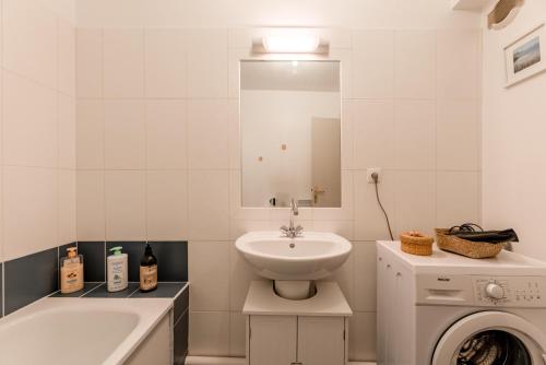 a white bathroom with a sink and a washing machine at "Hinkley" Centre ville Place de parking privé in Dieppe