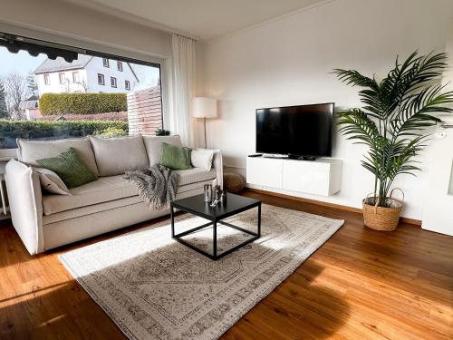 a living room with a couch and a tv at Feldbergblick mit Schwimmbad und Sauna in Lenzkirch