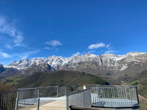 a bench sitting on a balcony with mountains in the background at Apartamentos Calm & Nature - Adults Only in Cabezón de Liébana