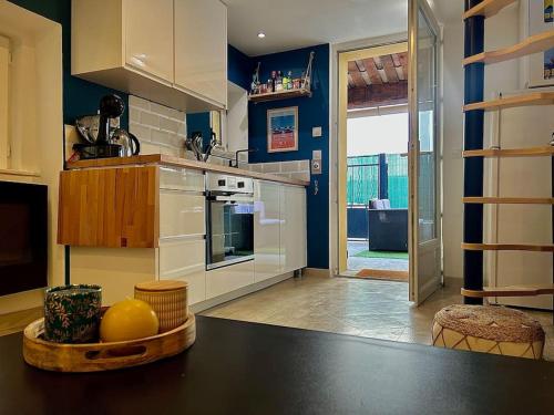 une cuisine avec une table avec un bol de fruits dessus dans l'établissement Petite maison atypique à Nice, à Nice