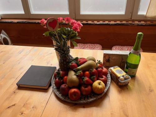 a bowl of fruit on a table with a bottle of wine at FeWo Parkblick HH Schanze in Hamburg