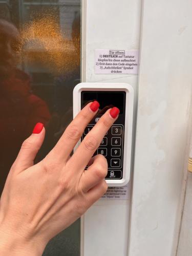 a woman with red nails holding a pay phone at FeWo Parkblick HH Schanze in Hamburg