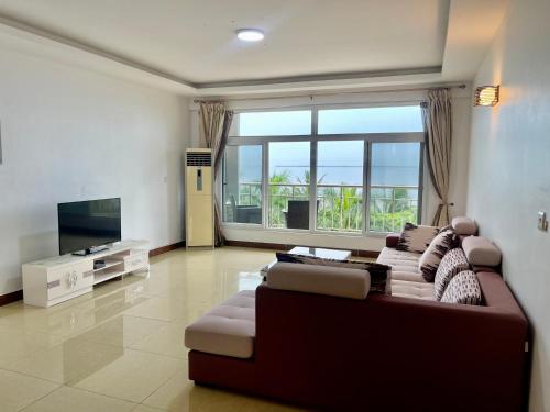 ein Wohnzimmer mit einem Sofa und einem großen Fenster in der Unterkunft Arrabella Ocean View Home in Daressalam