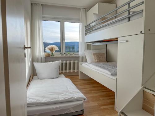 a small room with bunk beds and a window at Feldbergblick mit Schwimmbad und Sauna in Lenzkirch