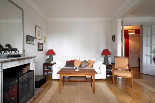 un salon avec un canapé blanc et une table dans l'établissement Appartement Apalta - Welkeys, à Paris