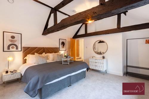 a bedroom with a large bed and a mirror at Modern 3 Bedroom Apartment - Wokingham in Wokingham