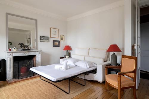 un salon avec un canapé blanc et une cheminée dans l'établissement Appartement Apalta - Welkeys, à Paris