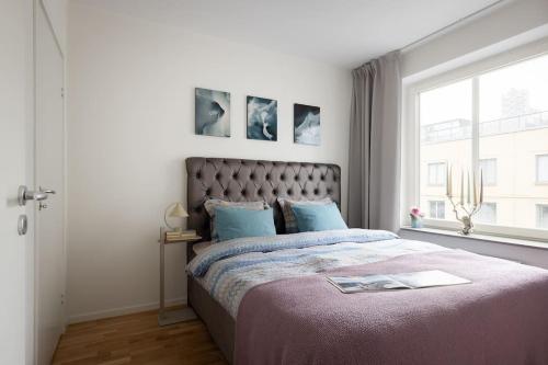 Un dormitorio con una cama grande y una ventana en Modern elegance i Hagastaden en Estocolmo
