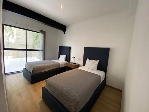 1 dormitorio con 2 camas y ventana en Departamento Nuevo en Puebla, la paz 101, en Momoxpan