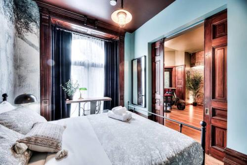 um quarto com uma cama grande e uma janela em Location, Comfort, & Convenience - Steam Punk MTL em Montreal