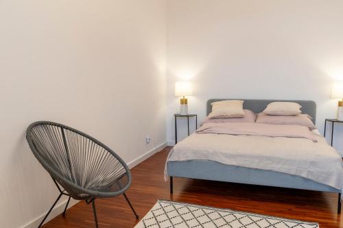 a bedroom with a bed and a chair at Mokotowska 7 in Warsaw