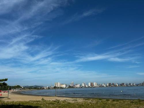 a view of a beach with a city in the background at Apartamento pé na areia 5 pessoas (Beto Carrero). in Penha