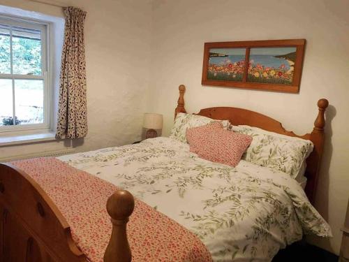 um quarto com uma cama e uma fotografia na parede em Traditional Irish Thatched Cottage em Florencecourt