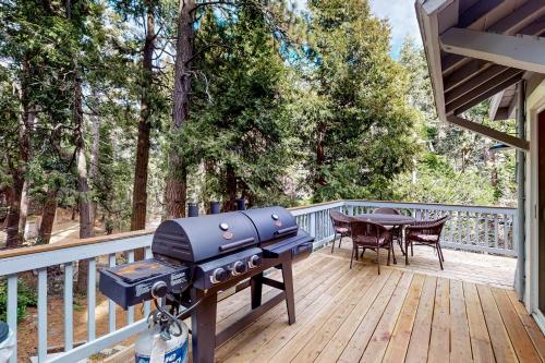 a grill on a wooden deck with a table and a table at Black Feather Lodge in Lake Arrowhead