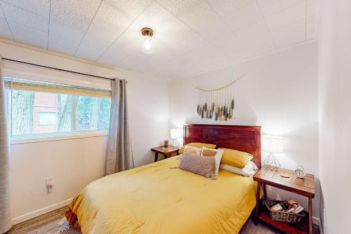 a bedroom with a yellow bed and a window at Black Feather Lodge in Lake Arrowhead