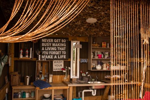 a room with a table and a sign on the wall at The Follies Glamping in Maidstone