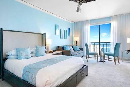 マイアミにあるThe Palms, Ocean View Studio Located at Ritz Carlton - Key Biscayneのベッドルーム(大型ベッド1台付)、リビングルームが備わります。