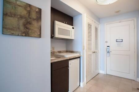 a kitchen with a sink and a microwave at The Palms, Ocean View Studio Located at Ritz Carlton - Key Biscayne in Miami