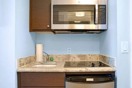 a kitchen with a sink and a microwave at The Palms, Ocean View Studio Located at Ritz Carlton - Key Biscayne in Miami