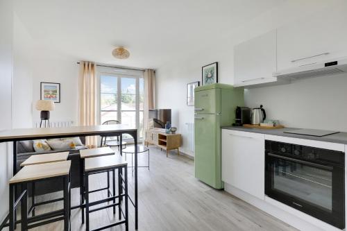Il comprend une cuisine équipée d'un réfrigérateur vert et d'une table. dans l'établissement La Résidence Alpha Viroflay 202 - 1 chambre - 2 pers, à Viroflay