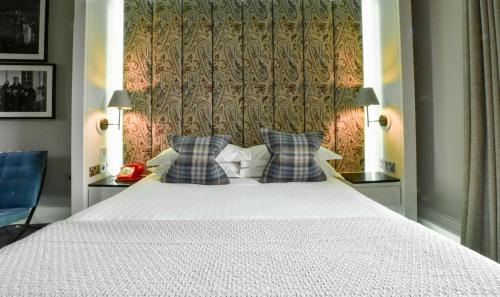 a bedroom with a large white bed with two pillows at The Rutland Hotel & Apartments in Edinburgh