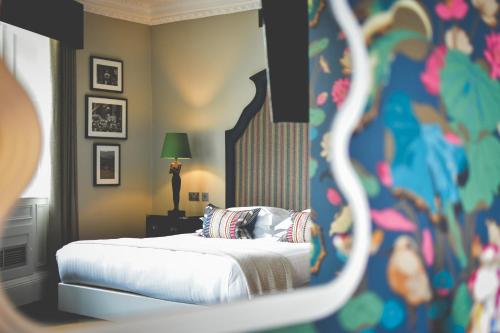 a bedroom with a bed with white sheets and pillows at The Rutland Hotel & Apartments in Edinburgh