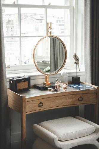 a dressing table with a mirror and a window at The Rutland Hotel & Apartments in Edinburgh