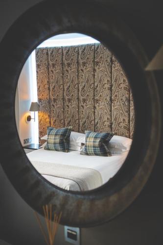 a bedroom with a bed with pillows in a mirror at The Rutland Hotel & Apartments in Edinburgh