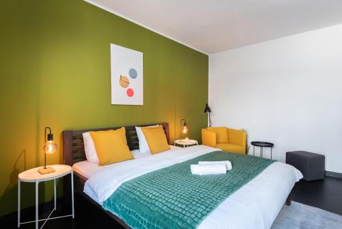 um quarto com uma cama grande com paredes amarelas e verdes em Lux apartments with an elegant balcony Prague em Praga
