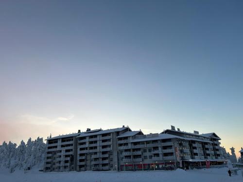 un grand bâtiment dans la neige dans l'établissement Chalets LumiHelmi, à Ruka