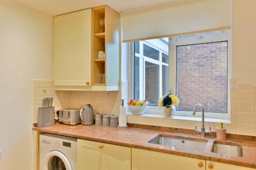 uma cozinha com um lavatório e uma janela em Lovely flat near University of Reading em Reading
