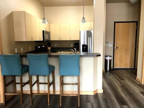 a kitchen with a counter and blue bar chairs at Cannery Square Apartment 104 in Sun Prairie