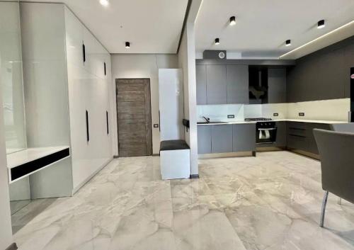 a large kitchen with white cabinets and a large tile floor at Gregori Home of Silence 2 