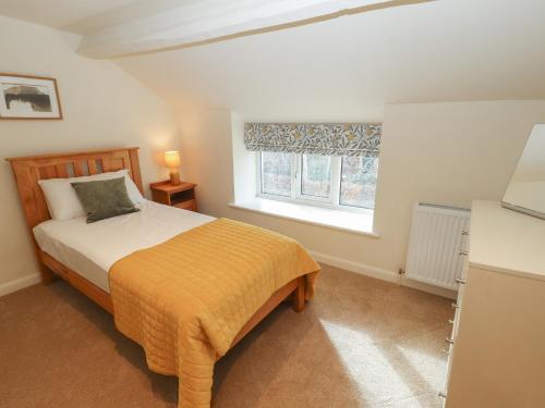 een slaapkamer met een bed en een raam bij Cobble Cottage in Keswick