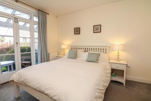 a bedroom with a large white bed and a window at 2 Dart in Stoke Gabriel