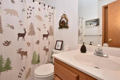 a bathroom with a toilet and a shower curtain with deer at 5123 Summit View Court in Somerset