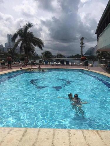- un groupe de personnes se baignant dans une piscine dans l'établissement Comfortable apartmento frente al mar, A/C / POOL, à Carthagène des Indes