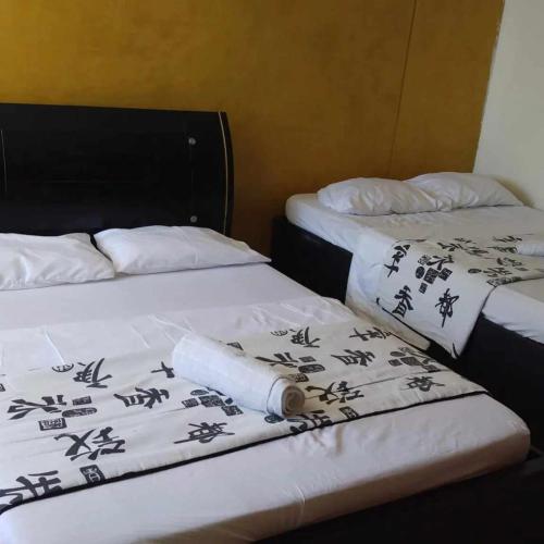 2 lits avec des draps noirs et blancs et un rouleau de papier dans l'établissement Comfortable apartmento frente al mar, A/C / POOL, à Carthagène des Indes