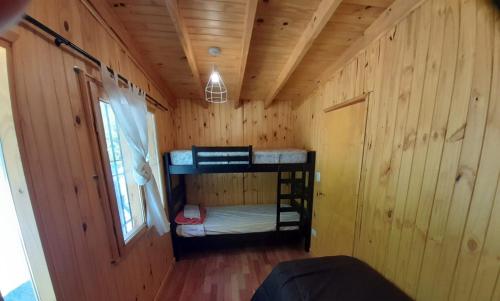 a room with two bunk beds in a wooden wall at Los Alamos in Plottier