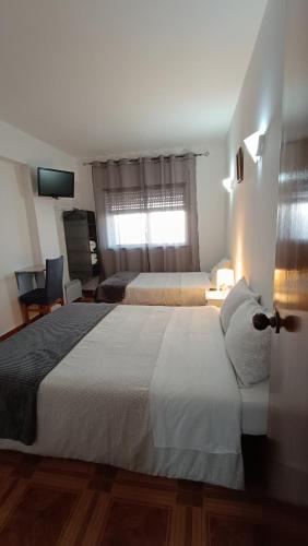 a hotel room with two beds and a window at Residencial S. Gião in Valença