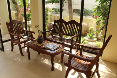 un porche con 2 sillas, una mesa y un banco en Anahaw Studio Suites, en Boracay