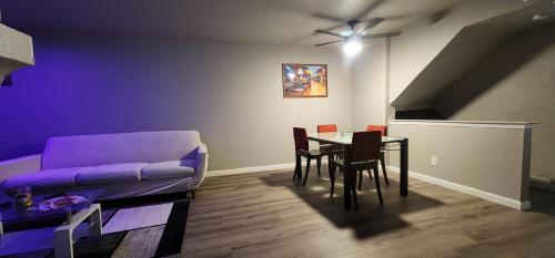 a living room with a table and a purple couch at Large Condo in the heart of Las Colinas, near Dallas in Irving