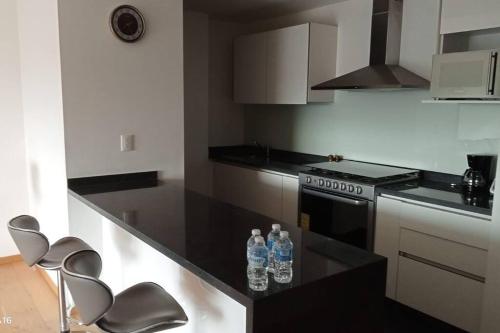 a kitchen with two bottles of water sitting on a counter at Departamento nuevo en High Towers Elite, Sonata in Lomas de Angelopolis