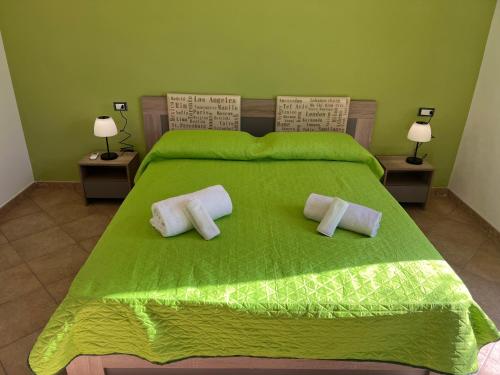 1 dormitorio con 1 cama verde y 2 almohadas en VIKY apartments, en Buonfornello