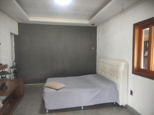 ein Schlafzimmer mit einem Bett in einem Zimmer in der Unterkunft Chalé Canastra Zoo in Capitólio