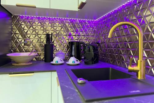 a purple kitchen with a sink and purple lighting at Hanza Tower Apartment No. 524 - Swimming pool, jacuzzi, balcony in Szczecin