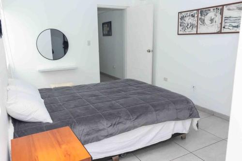 a bedroom with a bed with a mirror on the wall at Apartamento D&D Huanchaco in Huanchaco