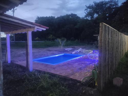 ein Pool in einem Garten mit einem Zaun in der Unterkunft Chalé Canastra Zoo in Capitólio