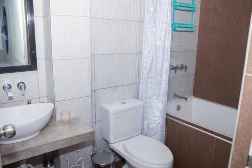 a bathroom with a toilet and a sink and a tub at Apartamento D&D Huanchaco in Huanchaco