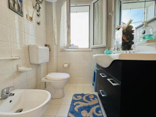a bathroom with a sink toilet and a window at Casa vacanza "Orchidea" in Marzamemi